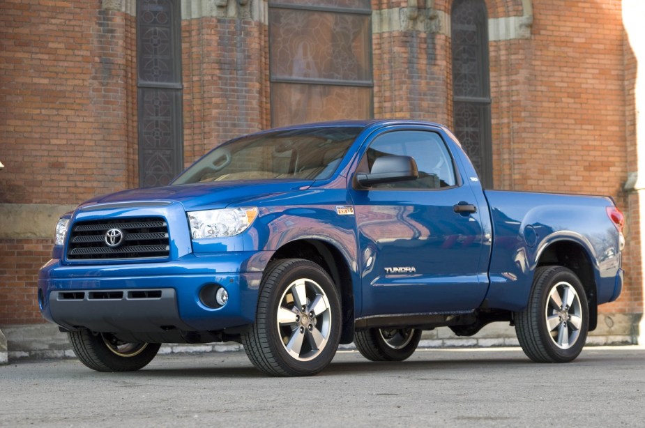 Blue 2007 Toyota Tundra full size pickup truck parked in front of a brick wall.