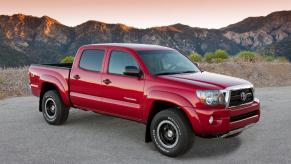 Red 2011 Toyota Tacoma TRD Pro trim parked in front of a mountain range for a promo photo.
