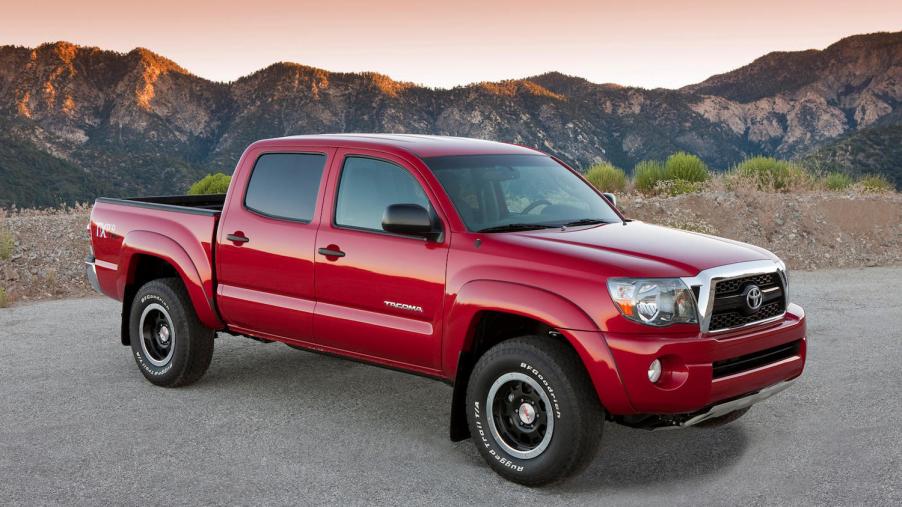 Red 2011 Toyota Tacoma TRD Pro trim parked in front of a mountain range for a promo photo.