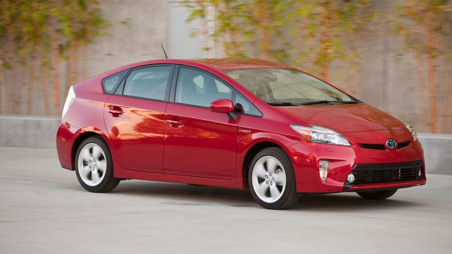 Toyota Prius hybrid driving in front of ivy plants for a promo photo.