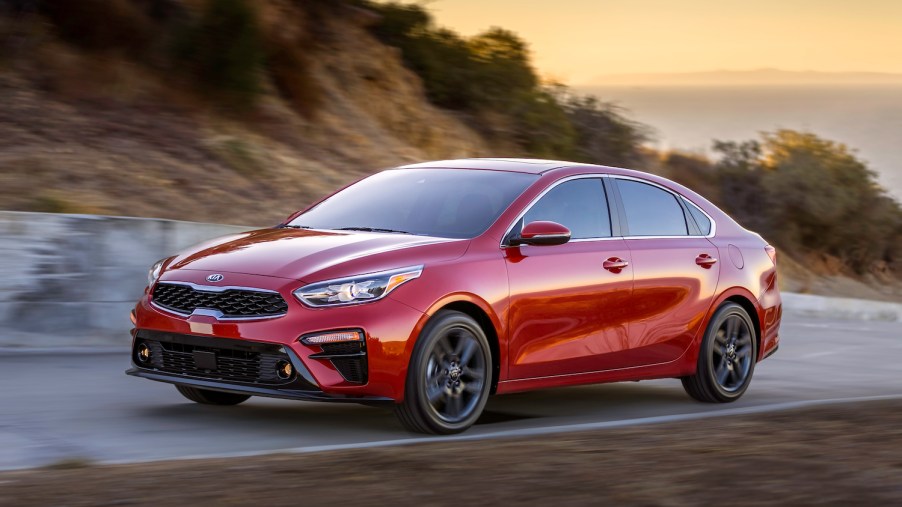 A red 2019 Kia Forte used car parked at dusk
