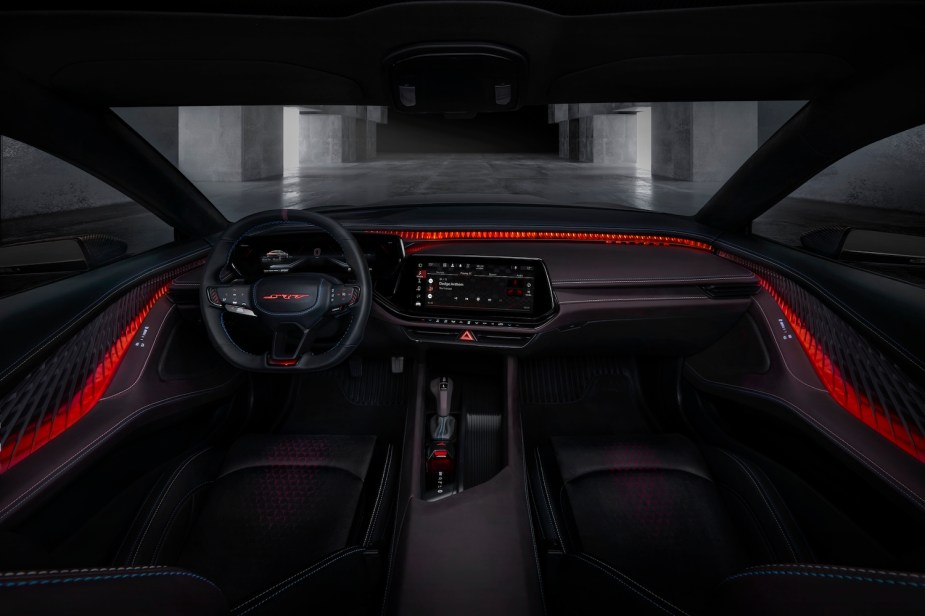 The illuminated interior of Dodge's new Charger Daytona SRT Banshee EV concept car, a concrete garage visible through the windshield.
