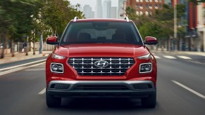 A red 2022 Hyundai Venue is driving on the road.