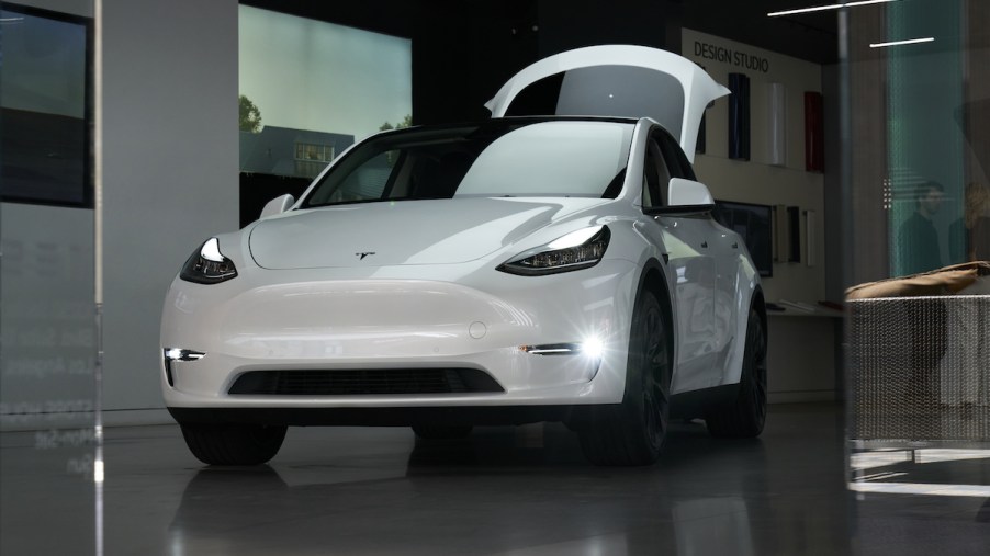 A white Tesla Model Y parked indoors, which is not as good as the 2023 Mercedes-Benz EQB.