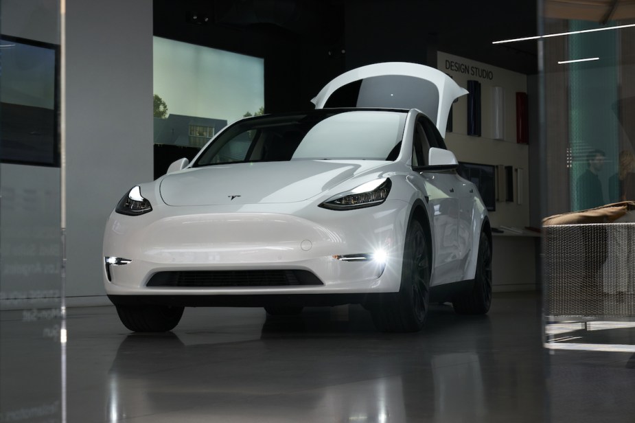 A white Tesla Model Y parked indoors, which is not as good as the 2023 Mercedes-Benz EQB. 