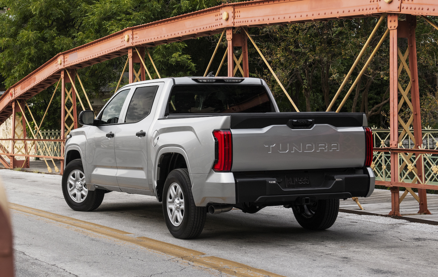A silver, third generation Toyota Tundra parked on a bridge, facing away from the camera.