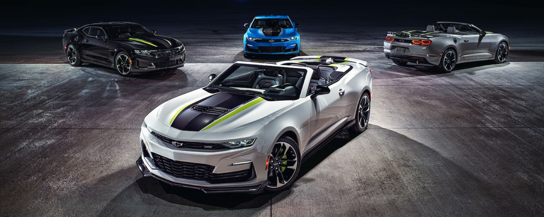 A collection of 2023 Chevy Camaro sports car/muscle car models parked on a concrete floor