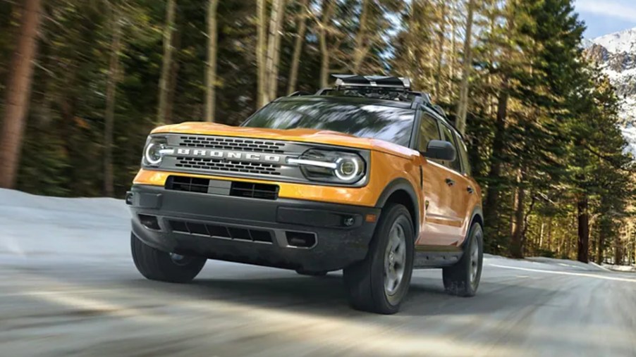 A yellow 2023 Ford Bronco Sport is driving on the road.