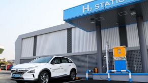 A white 2023 Hyundai Nexo hydrogen fuel cell vehicle at an H2 refueling station