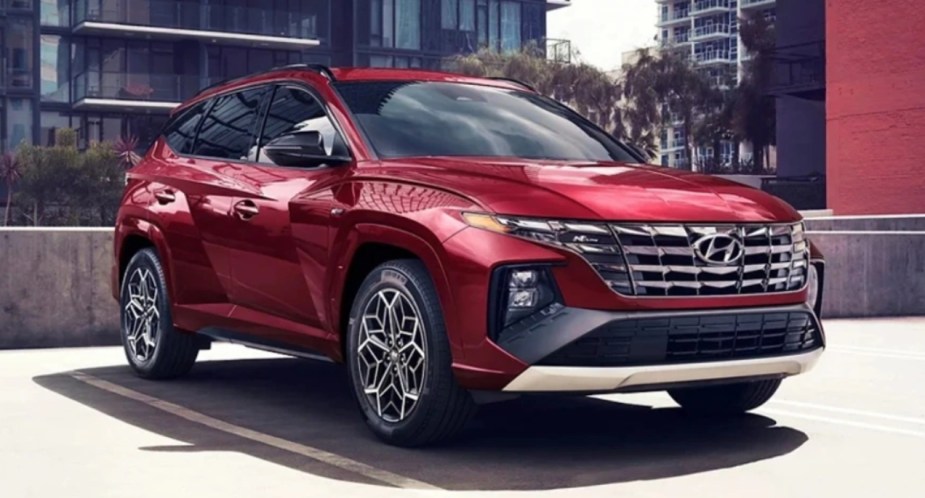 A red 2023 Hyundai Tucson small SJUV is parked, experts disagree about the best trim.