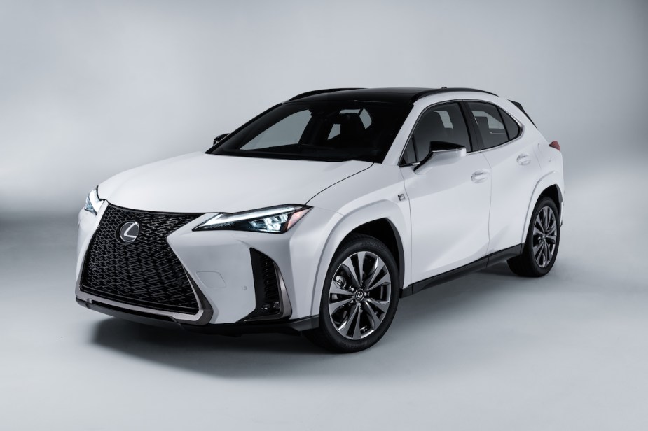 A white 2023 Lexus UXh in a white room, an affordable luxury hybrid SUV.