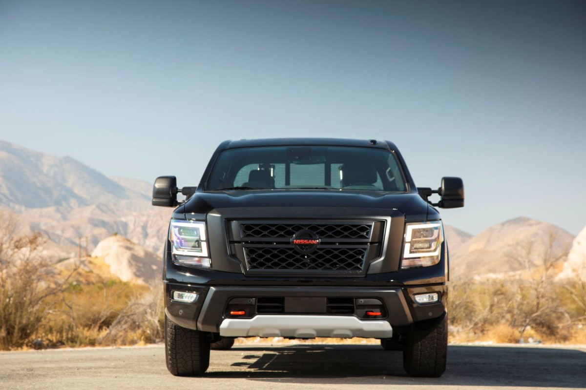 A front-facing shot of a black 2023 Nissan Titan full-size pickup truck model parked in a desert location