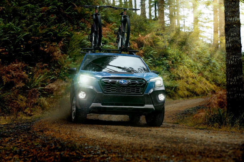 A Blue 2023 Subaru Forester Wilderness small off-road SUV is parked on a trail.