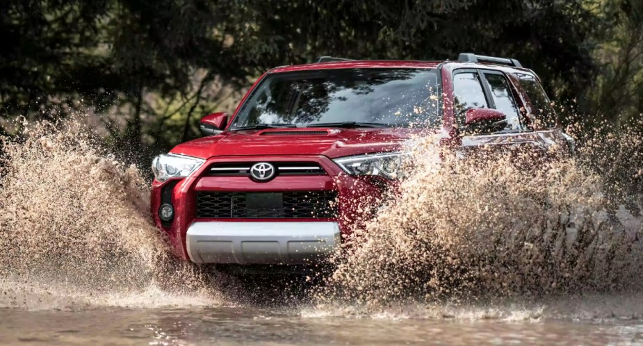 A red 2023 Toyota 4Runner is driving through the water.