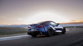 A blue 2023 Toyota GR Supra driving in the distance