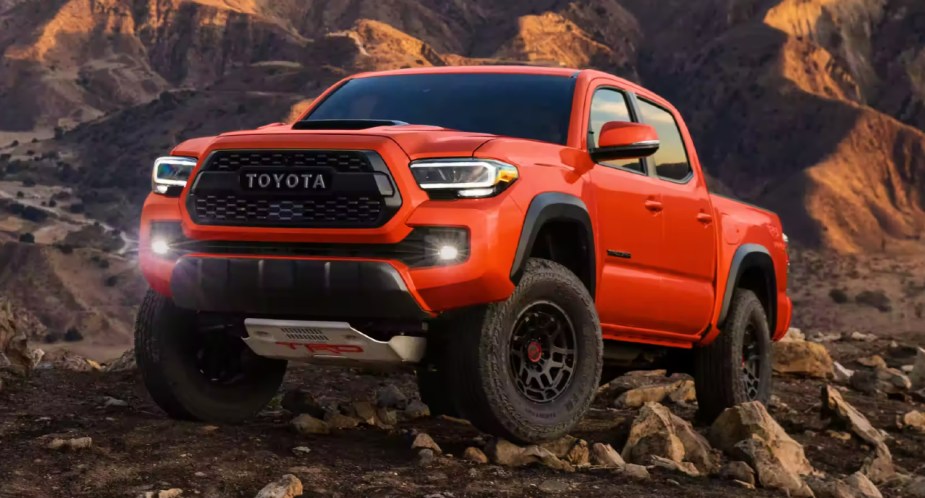 An orange 2023 Toyota Tacoma TRD Pro is parked off-road. 