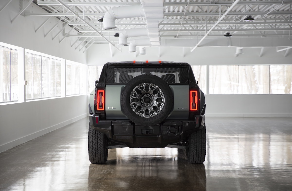 2024 GMC Hummer EV taillights while parked in a while room with many windows.