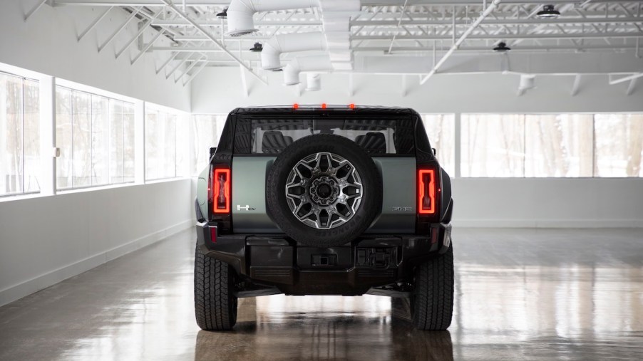 2024 GMC Hummer EV taillights while parked in a while room with many windows.