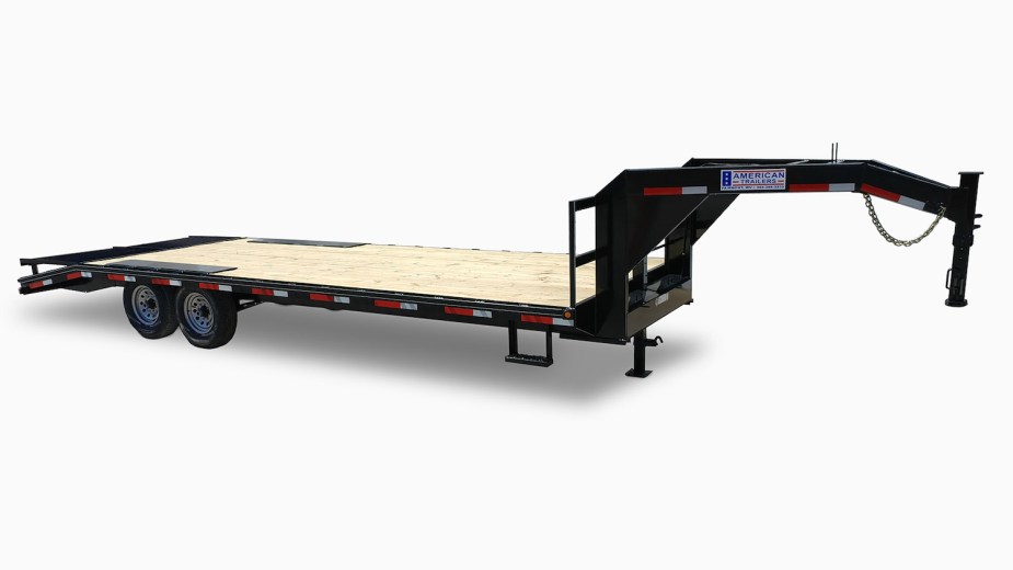 Product photo of a black gooseneck trailer with a woodplank flatbed built by American Trailers.