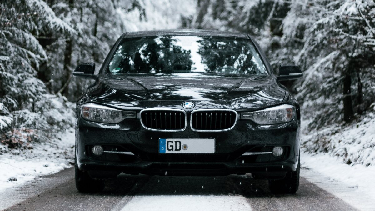 BMW on a snowy road, highlighting if cars with a black color are warmer in the winter