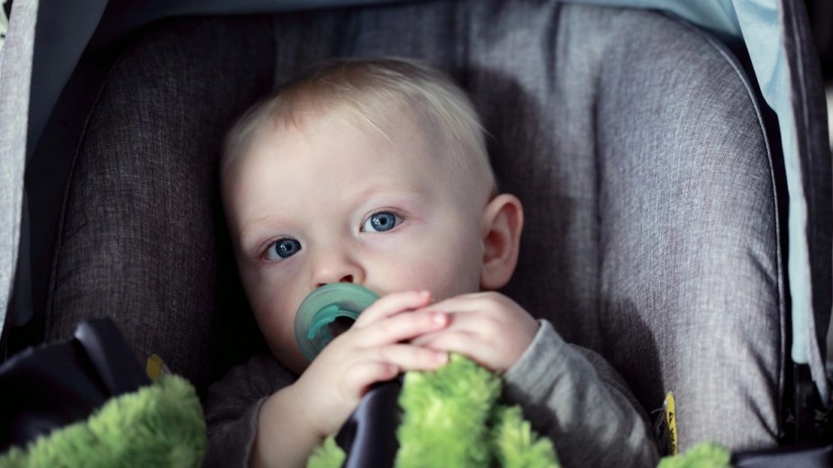 Baby sitting in a car seat, highlighting why some babies hate car seats and how to address it 