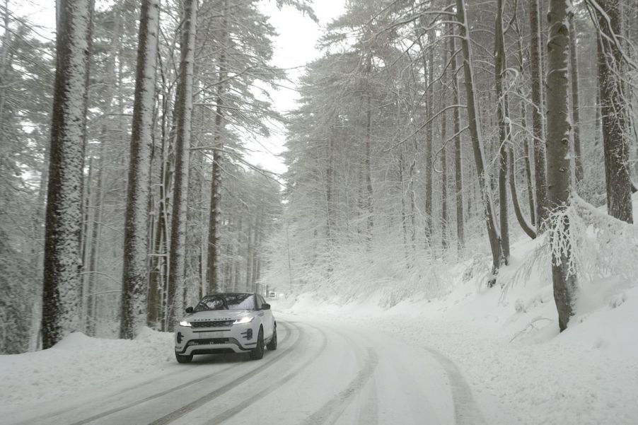 A car driving in snow where winter weather lowers fuel economy.