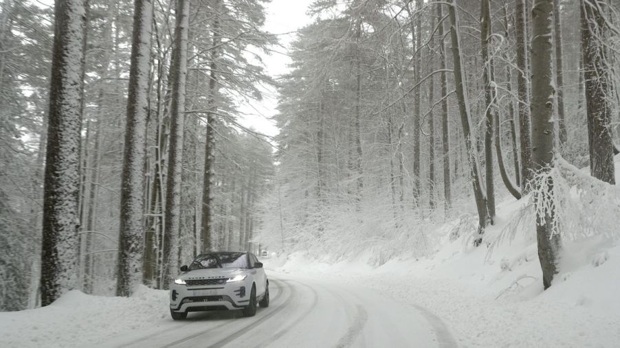A car driving in snow where winter weather lowers fuel economy.