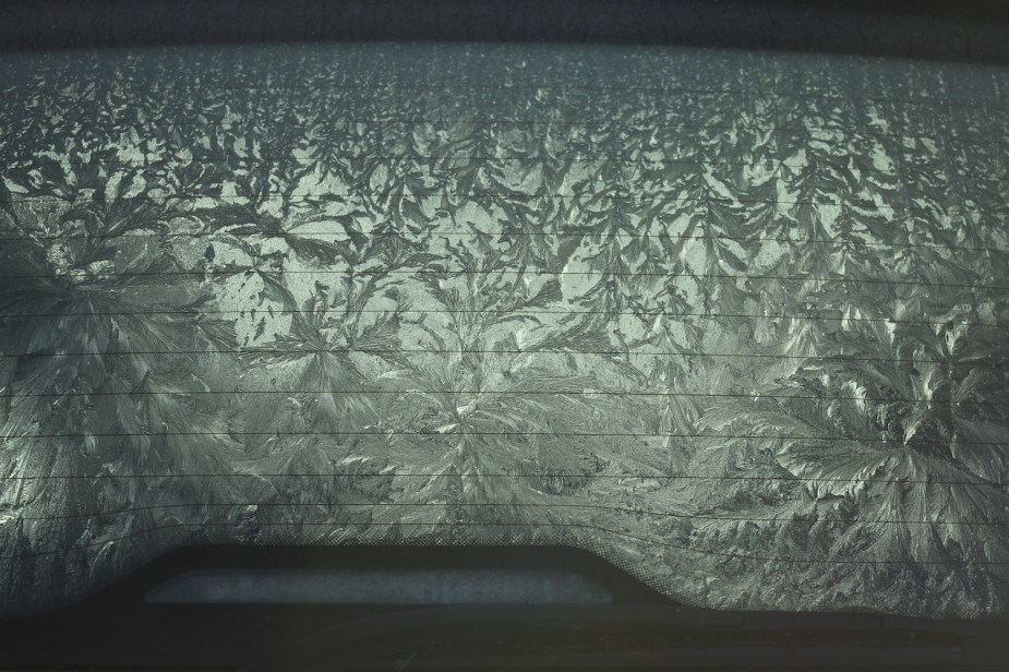 Closeup of the ice crystals forming on the back window of a frost-covered car.