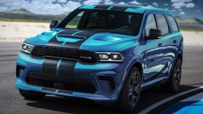 A blue 2023 Dodge Durango SRT Hellcat is driving on a track.