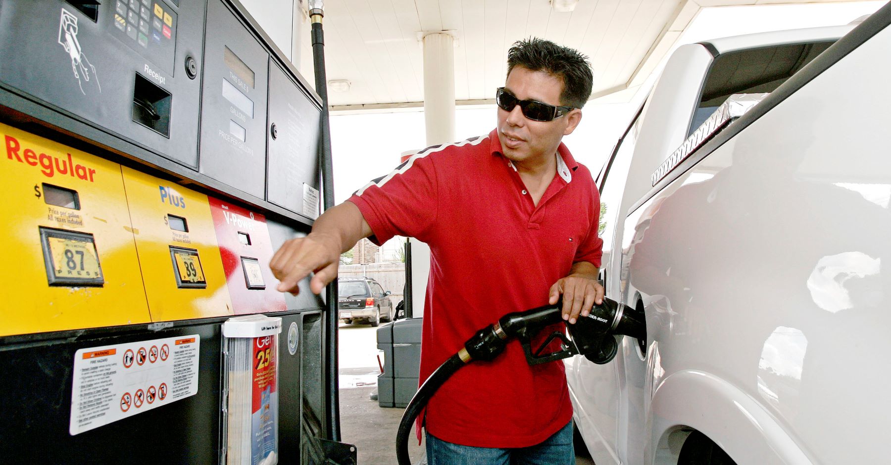 A man refueling his Ford F-150 at a Shell gas station in Houston, Texas