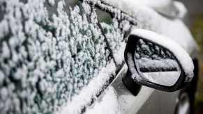 A snow covered car that is showing the effects winter weather has on your car you may not think about.