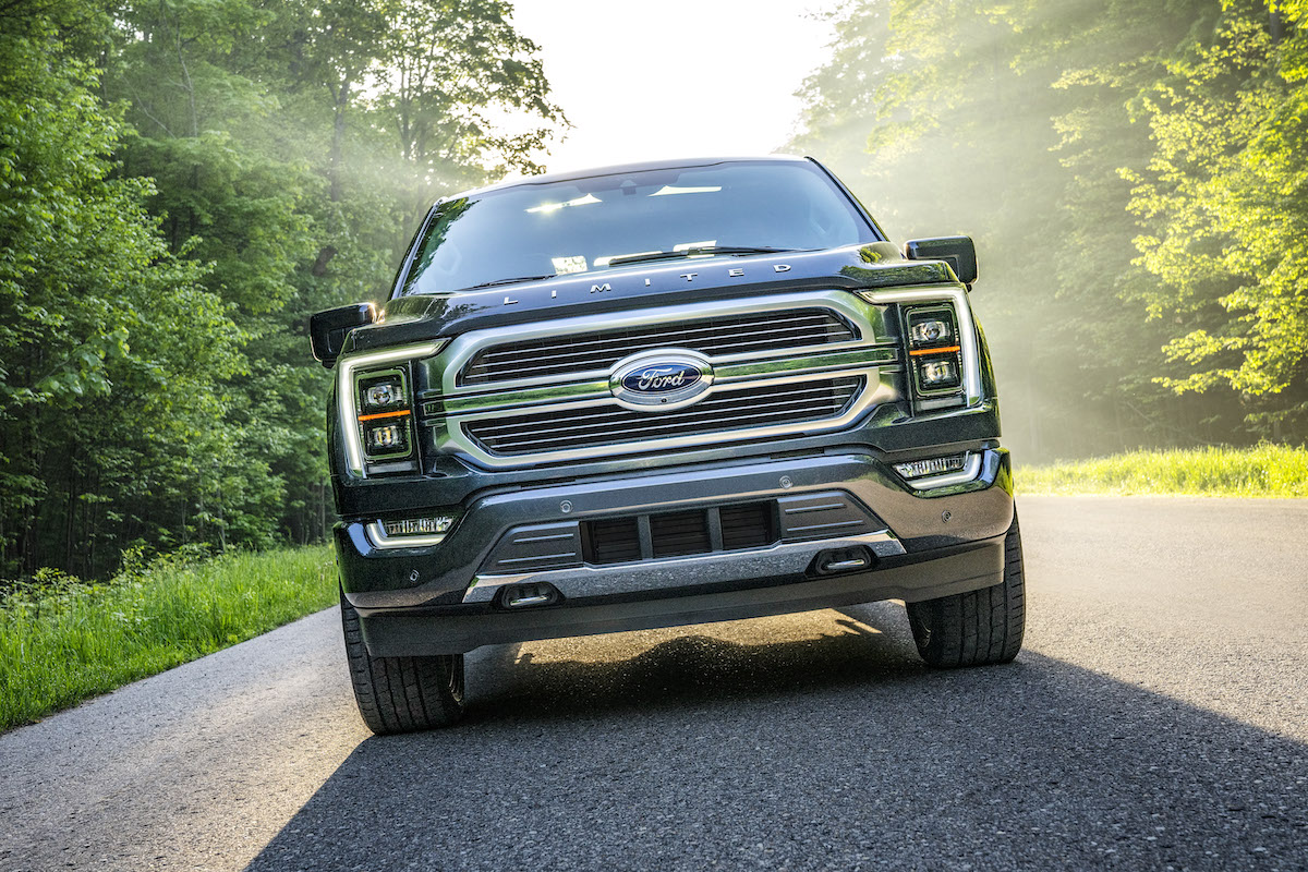 The Ford F-150 driving in a wooded area, which the Ford F-150 hybrid sales are plummeting.