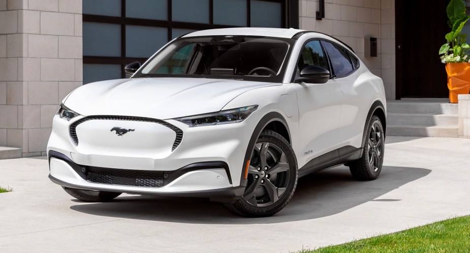 A white 2023 Ford Mustang Mach-E small electric SUV is parked outside. 