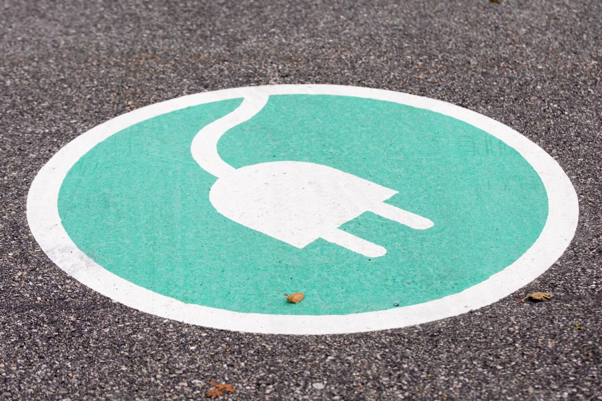 A charging sign painted on a parking spot for electric vehicles.