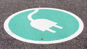 A charging sign painted on a parking spot for electric vehicles.