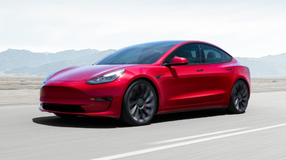 Front angle view of new red 2023 Tesla Model 3 electric car, highlighting how much a fully loaded one costs