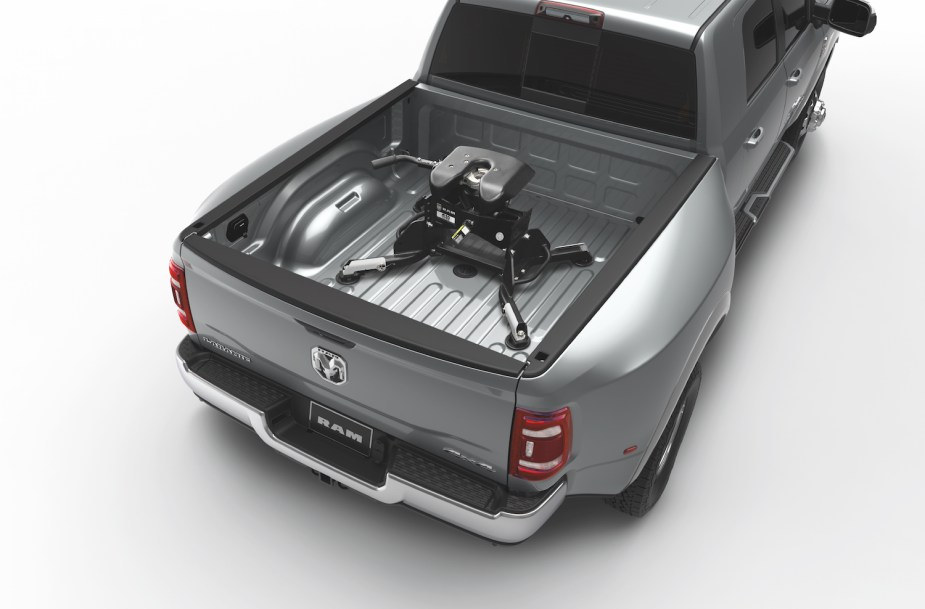 Silver heavy-duty Ram 3500 dually pickup truck with a 5th wheel hitch installed in its bed.