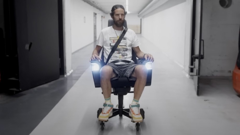 Man driving VW electric office chair in a hallway