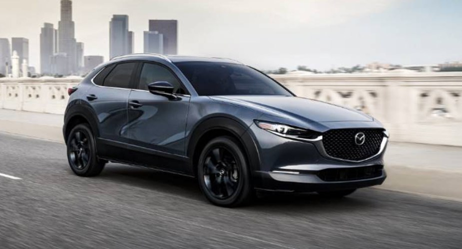 A blue 2023 Mazda CX-30 is driving on the road. 