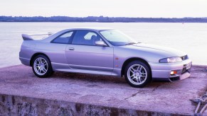 A silver R33 Nissan Skyline posing on a platform