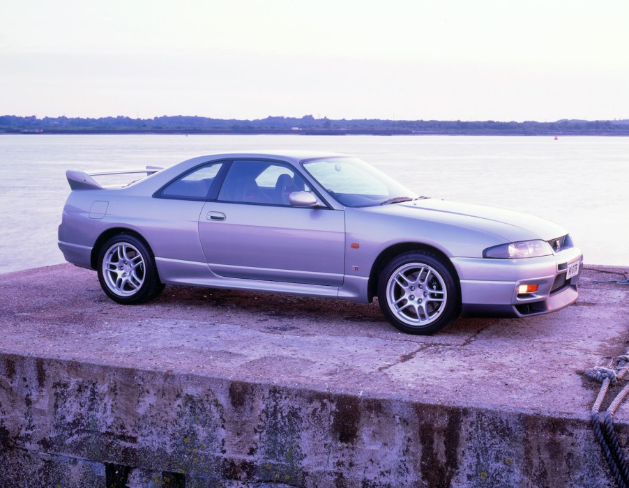 A silver R33 Nissan Skyline posing on a platform