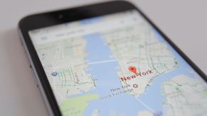 A phone accesses GPS to track a car and find a waypoint in New York.