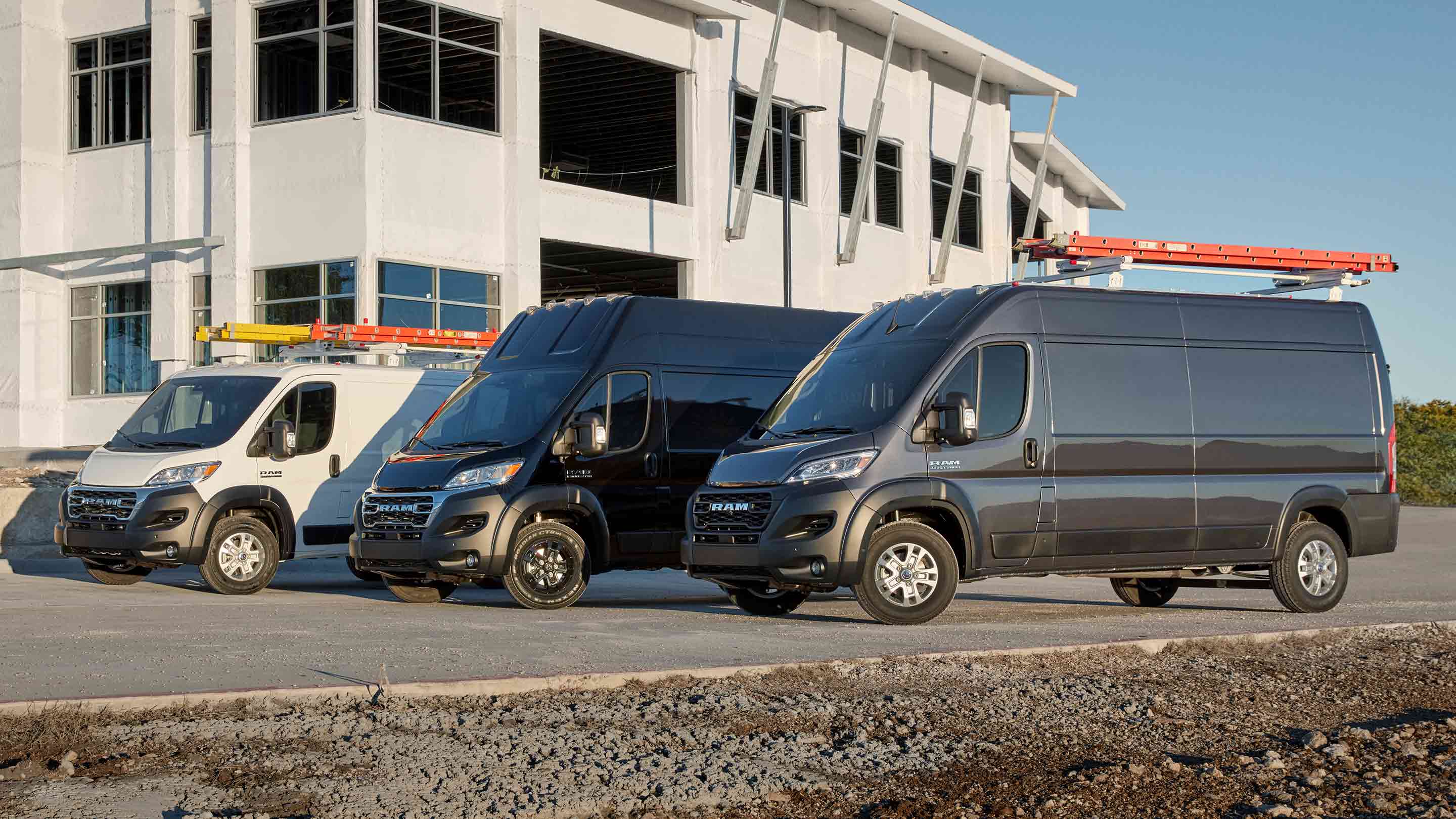 A group of 2023 Ram ProMaster models sit outside of a building.