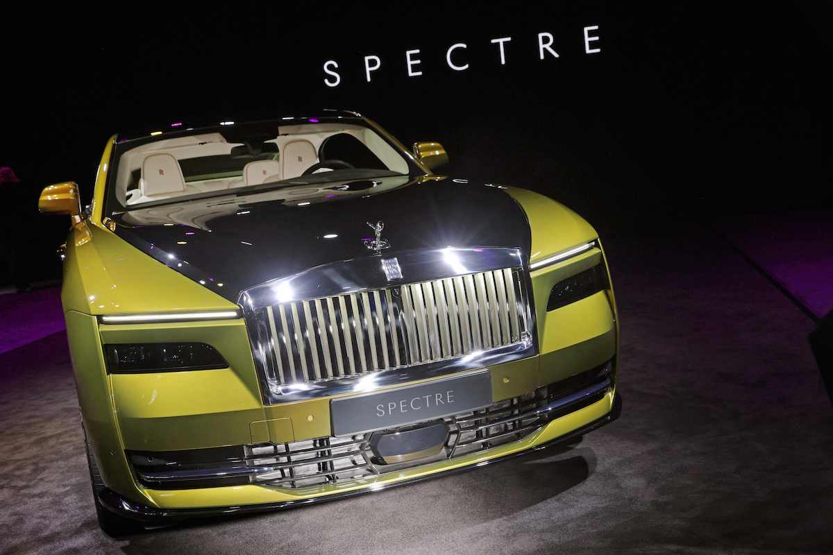 A multi-colored Rolls-Royce Spectre parked indoors.