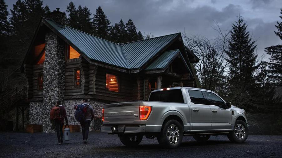 Silver 2023 Ford F-150 pickup truck, most popular car for wealthy people, parked near a cabin