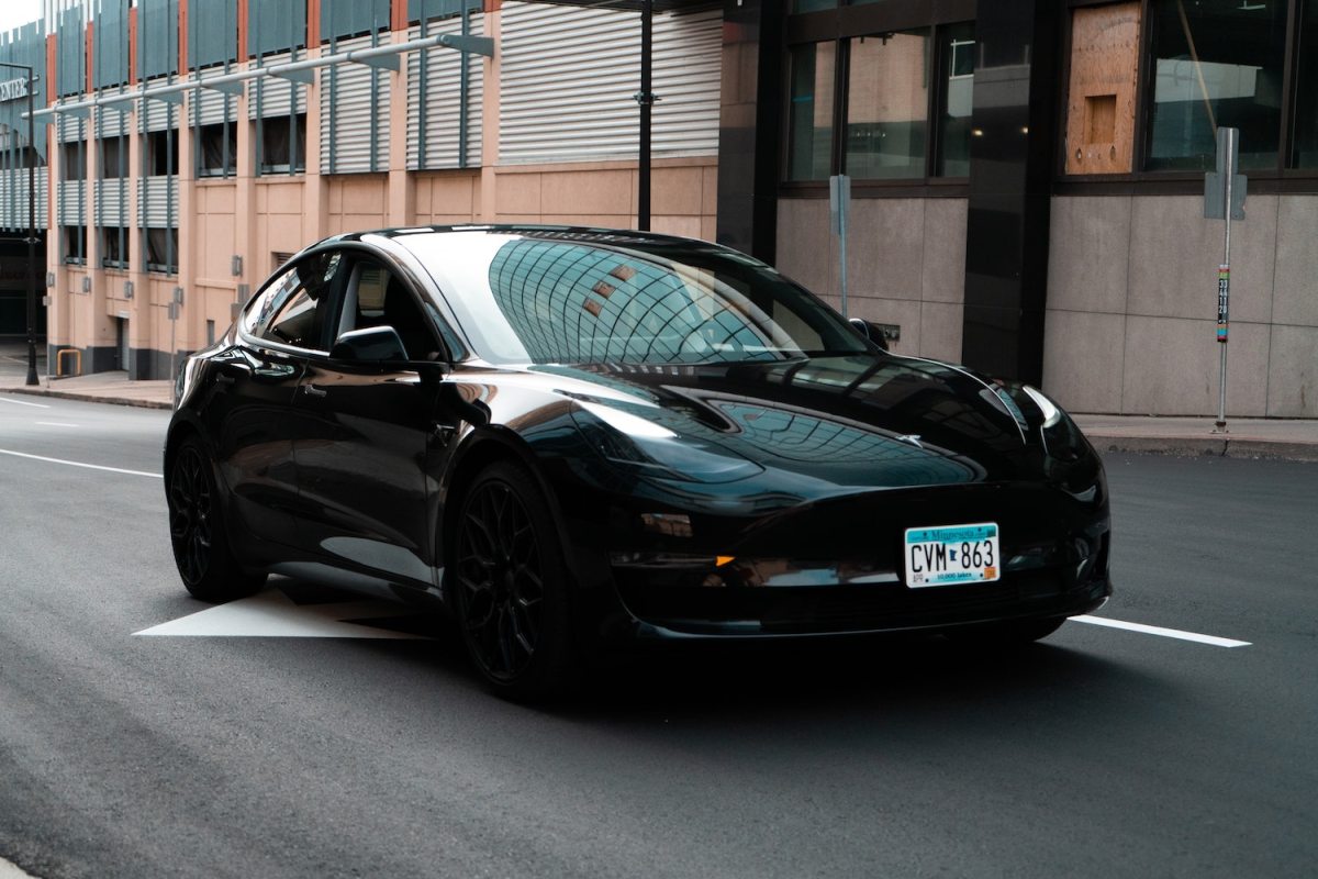 A Black Tesla model driving down a city street