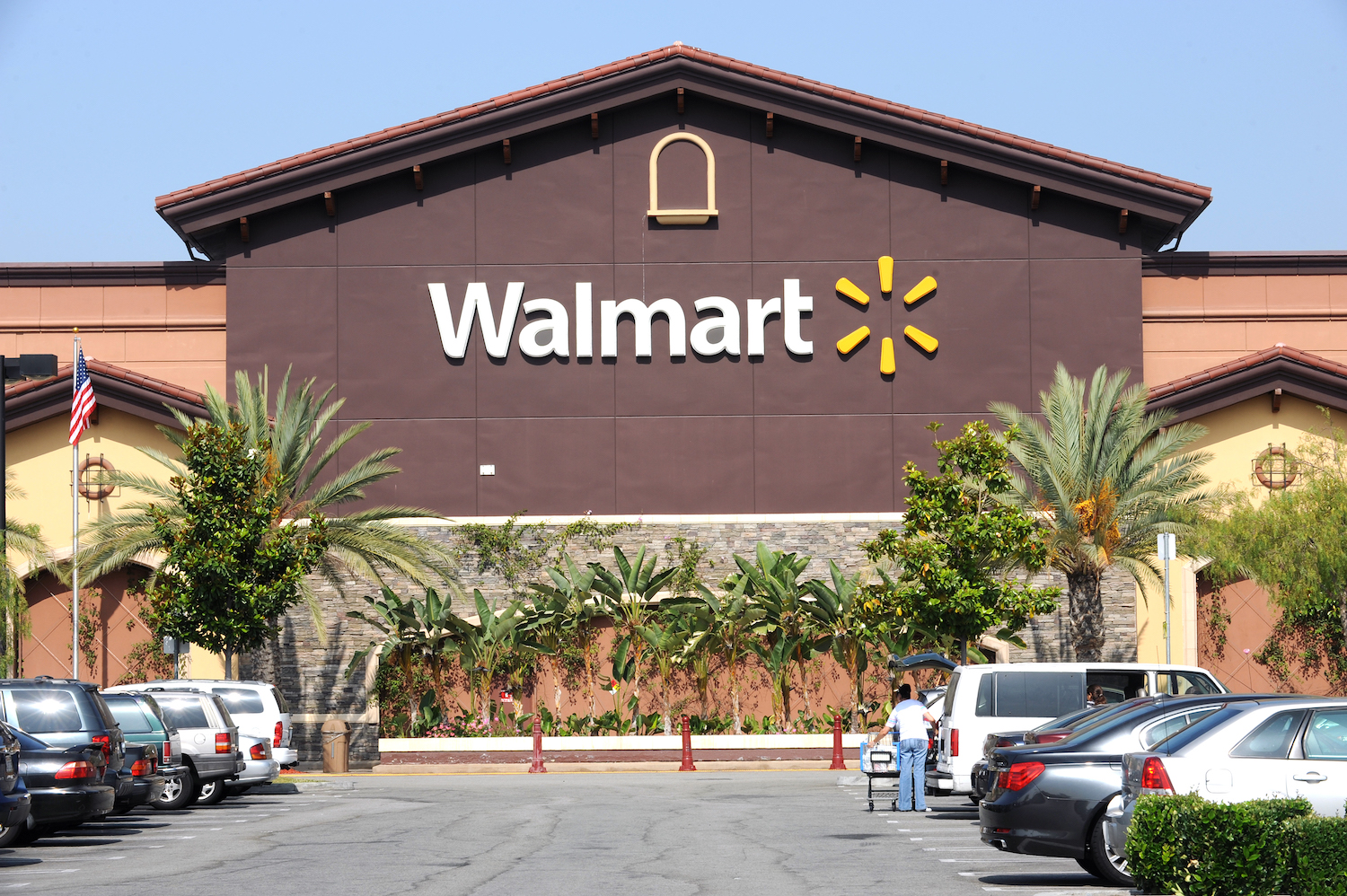 A walmart's storefront, palm trees visible in the foreground.
