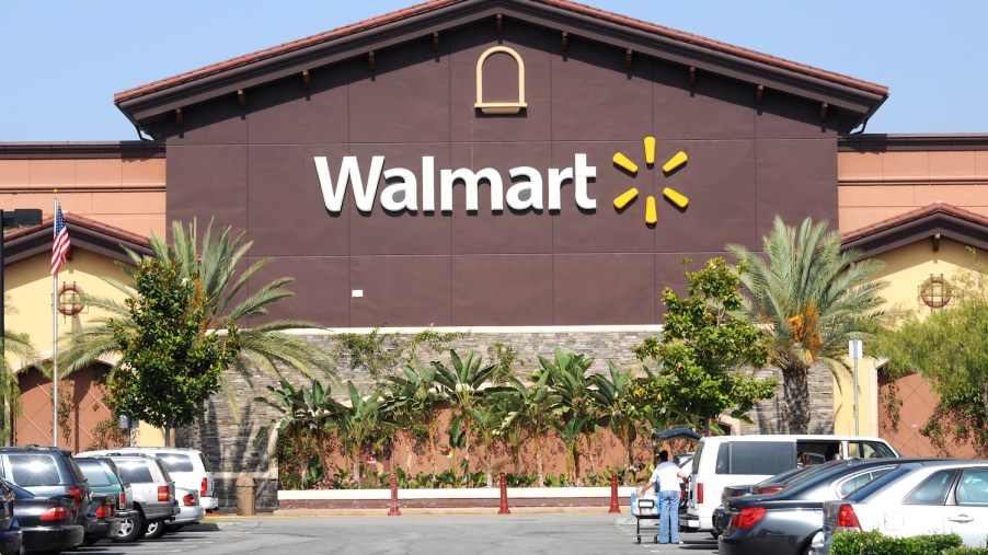 A walmart's storefront, palm trees visible in the foreground.