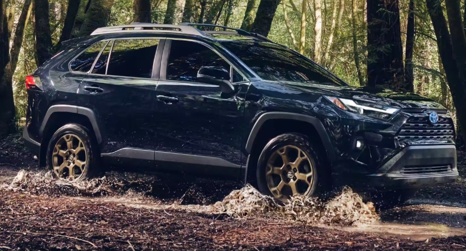 A blue 2023 Toyota RAV4 is driving off-road. 