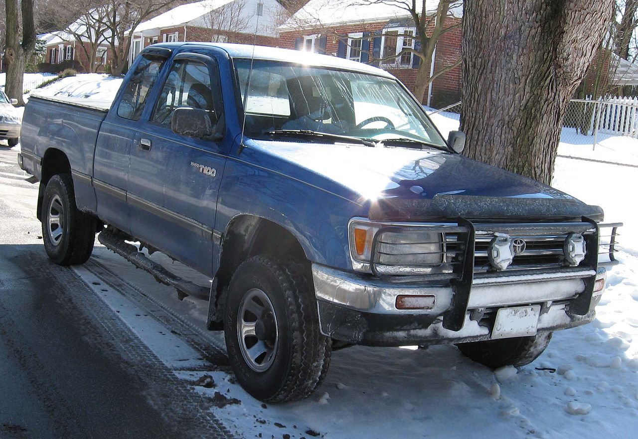 A Toyota T100 sits on a snowy road, it can be an off-road truck.
